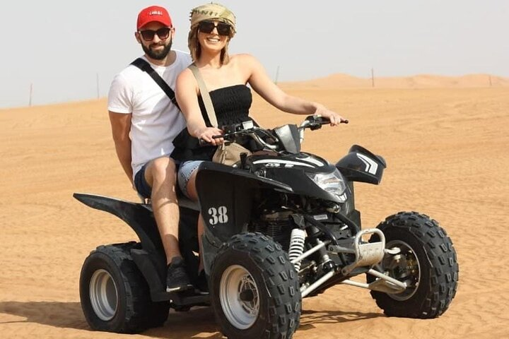 Experience the vast sands of Dubai as you ride a quad bike creating unforgettable moments amidst stunning desert landscapes and engaging in traditional Bedouin culture. Adventure awaits!